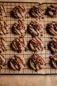 Die Walnussplätzchen mit Schokolade überziehen