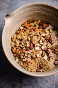 Die gerösteten Haselnüsse zum Quinoa geben