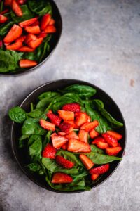 Spinat und Erdbeeren anrichten